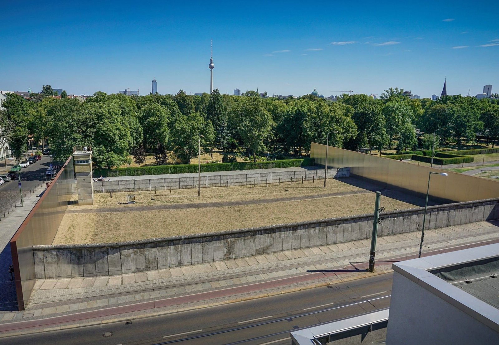 The preserved border strip of the Berlin Wall Memorial on Bernauer Straße, seen from above, with the TV tower in the distance