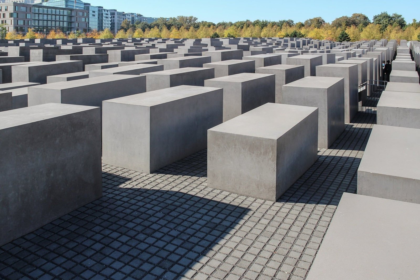 Rows of grey concrete stelae at the Memorial to the Murdered Jews of Europe on a sunny autumn day